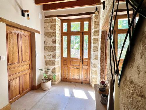 - un couloir avec une porte en bois dans une maison dans l'établissement Le Havre des Perrières - Gîte avec spa, 15 personnes, 5 chambres, à Vaudelnay