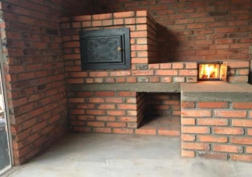 a brick wall with a fireplace with a tv on it at Espaço Vitali in Blinha