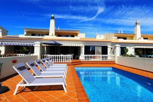 a villa with a swimming pool and two lounge chairs at Bela Vivenda-pretty Family Villa With Pool & Golf in Castro Marim