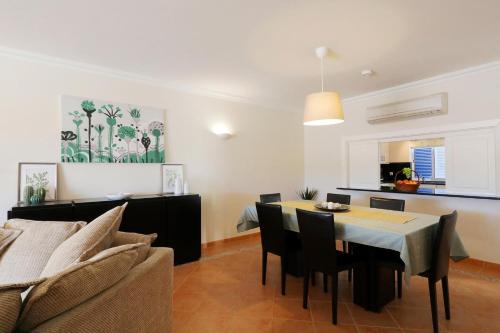 a dining room and living room with a table and chairs at Bela Vivenda-pretty Family Villa With Pool & Golf in Castro Marim