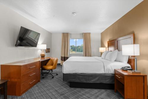 a hotel room with a bed and a desk and a television at Comfort Inn Hobart-Merrillville I-65 in Merrillville