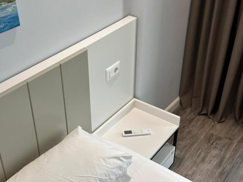 a bed with a white headboard next to a table at Auras Home in Vlorë
