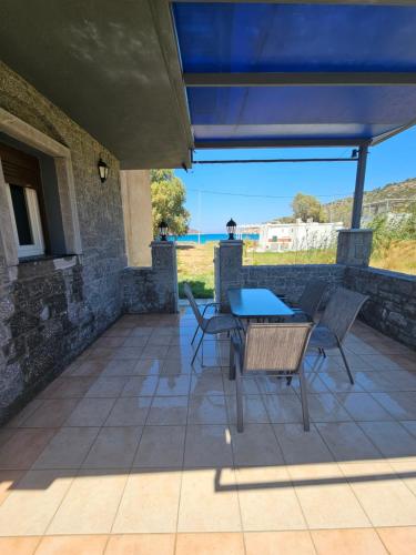 a patio with a table and chairs and the ocean at Porto Mesta Residence in Liménas