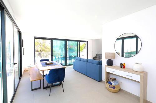 a living room with a table and a blue couch at Casa Emeline-stunning Family Villa With Pool in Tavira