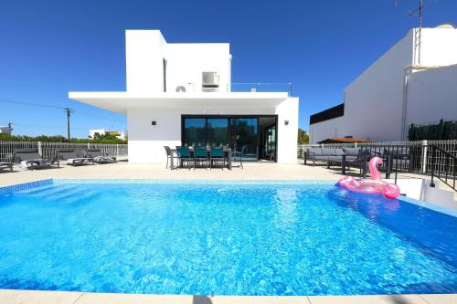 a villa with a swimming pool and a pink flamingo at Casa Emeline-stunning Family Villa With Pool in Tavira