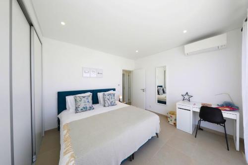 a white bedroom with a bed and a desk at Casa Emeline-stunning Family Villa With Pool in Tavira