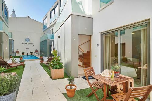 a house with a patio with a table and chairs at Stylish Townhouse In Tavira Centre, Shared Pool in Tavira