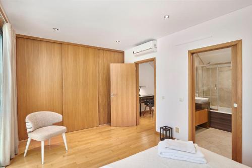 a bedroom with a bed and a chair and a desk at Stylish Townhouse In Tavira Centre, Shared Pool in Tavira