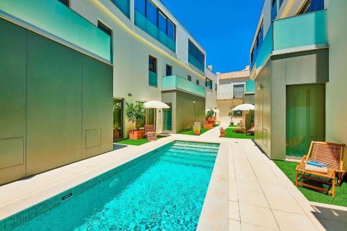 a swimming pool in the backyard of a house at Stylish Townhouse In Tavira Centre, Shared Pool in Tavira