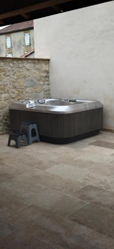 d'une baignoire installée dans l'angle du bâtiment. dans l'établissement Le jardin des sauges, à Dolmayrac