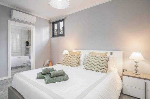 Un dormitorio con una gran cama blanca y un baño. en Villa Oceanscape, en Madalena do Mar