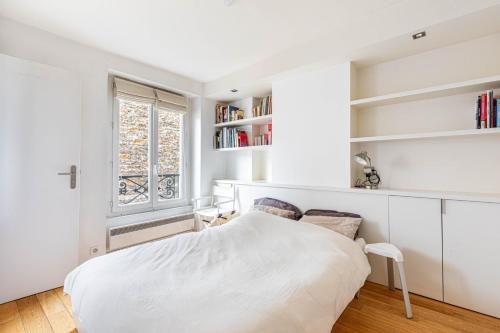 une chambre blanche avec un lit et une fenêtre dans l'établissement GuestReady - Confort et Élégance au Cœur de Paris, à Paris