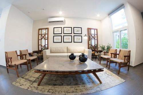 a living room with a couch and tables and chairs at Modern House Surrounded By Nature in Mérida