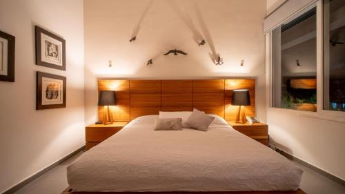 a bedroom with a bed and two lamps and a window at Modern House Surrounded By Nature in Mérida