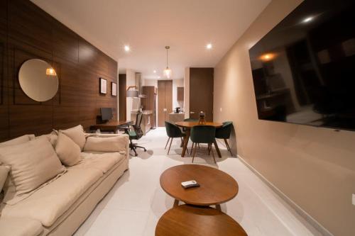 a living room with a couch and a table at PENINSULA STAYS 2 BR Designer Apartment & 200 MB FAST WIFI New Listing! in Mérida
