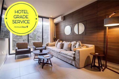 a living room with a couch and a table at PENINSULA STAYS 2 BR Designer Apartment & 200 MB FAST WIFI New Listing! in Mérida