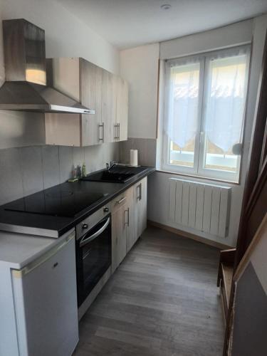 une cuisine avec un évier et une fenêtre dans l'établissement Le cottage de Jeanne, à La Fère