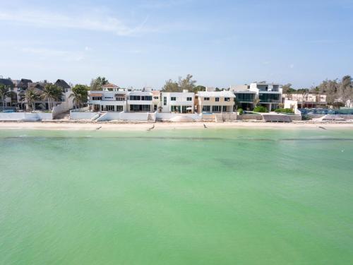 a view of a beach with houses in the background at PENINSULA STAYS 4BR Beach House @ PROGRESO The Best Location in the Yucatan in Progreso
