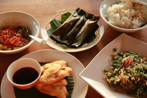 einen Tisch mit Teller mit Lebensmitteln und Schalen mit Reis in der Unterkunft North Bali Beachhouse Ayu in Umeanyar