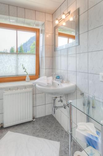 a bathroom with a sink and a mirror and a window at Michelerhof - kinderfreie Unterkunft in Lavant