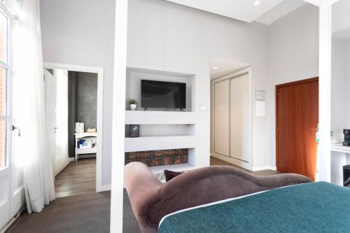 a living room with a couch and a tv at 1881 Hotel Balneario Vichy Catalan in Caldes de Malavella