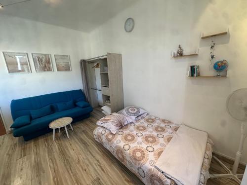 - un salon avec un canapé bleu et un lit dans l'établissement Etoile de Mer Magnifique STUDIO Déco Plage et sable fin, Votre séjour à Marseille commence ici, Centre-Ville, à Marseille
