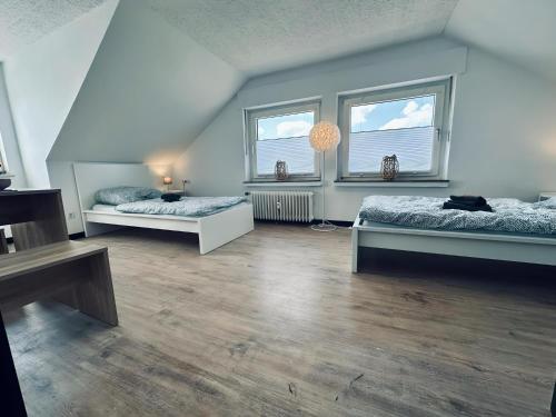 a large room with two beds and two windows at Apartment OchtrUP I Ruhig & Geräumig in Ochtrup