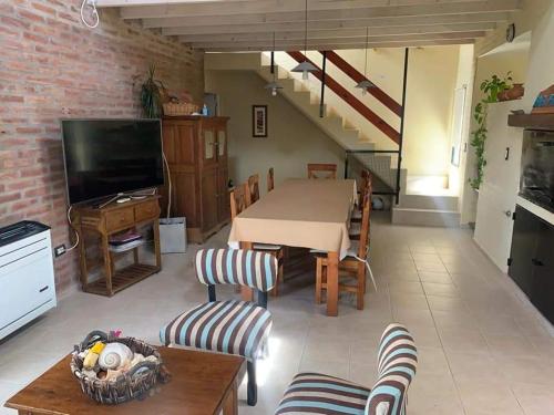 a living room with a table and a tv at BIG FISH El Cóndor in Balneario El Condor