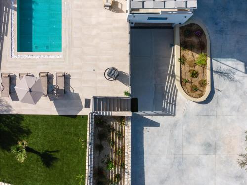 an overhead view of a building with a swimming pool at Garde Villa, with Private Pool, BBQ & Playground, By ThinkVilla in Roumelí