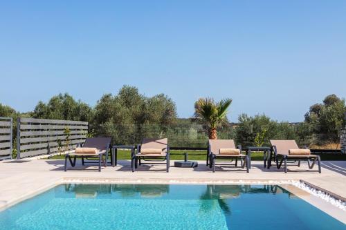 a patio with chairs and a swimming pool at Garde Villa, with Private Pool, BBQ & Playground, By ThinkVilla in Roumelí
