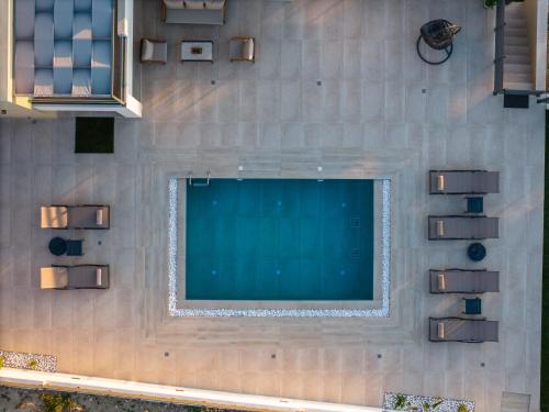 an overhead view of a large screen tv on a wall at Garde Villa, with Private Pool, BBQ & Playground, By ThinkVilla in Roumelí