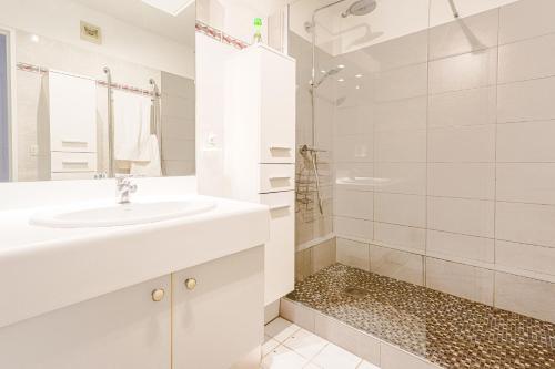 une salle de bain blanche avec un lavabo et une douche dans l'établissement 2 Pièces cœur Vieux Nice avec stationnement, à Nice