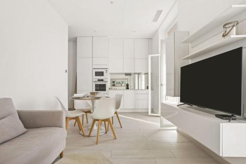 un salon avec une télévision à écran plat et un canapé dans l'établissement Vue mer 180 degrés à St Maxime, à Sainte-Maxime