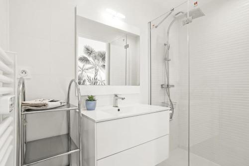 une salle de bain blanche avec un lavabo et une douche dans l'établissement Vue mer 180 degrés à St Maxime, à Sainte-Maxime