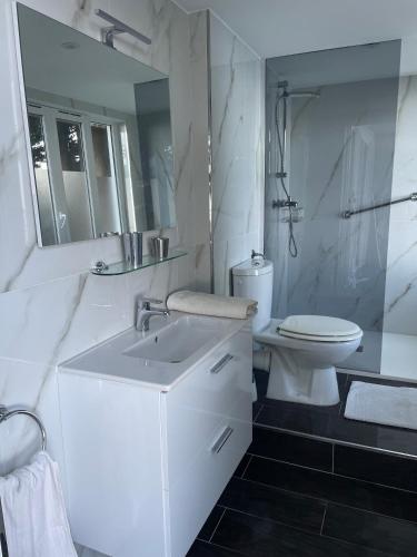 une salle de bain blanche avec un lavabo et des toilettes dans l'établissement Villa Riviera vue panoramique MER et NATURE, à Èze