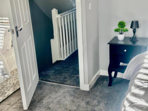 a bedroom with a stairway with a blue wall at Spacious 4-Bed House Close to City Centre in Wolverhampton