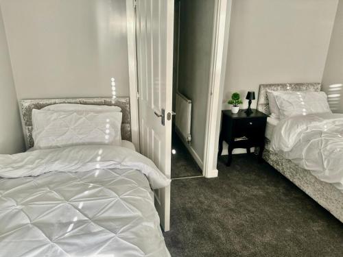 a bedroom with two beds and a mirror at Spacious 4-Bed House Close to City Centre in Wolverhampton