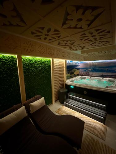 a room with a tub with a couch in front of it at Chaty Wichrowe Wzgórze in Krynica Zdrój