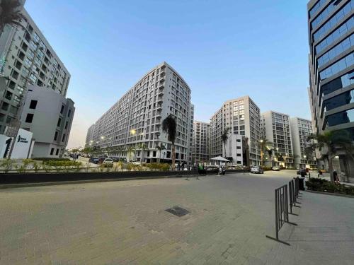a parking lot in a city with tall buildings at H Flat With Roof- One Kattamya in Cairo