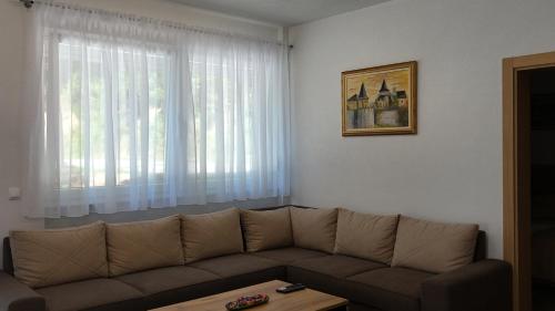 a living room with a couch and a window at Apartments Bioland in Kulen Vakuf