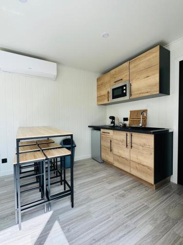 une cuisine avec une table et un comptoir dans l'établissement Chalet moderne avec piscine, à Vittel