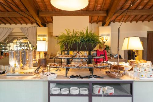 a woman standing in front of a counter with pastries at Borgo San Luigi in Monteriggioni