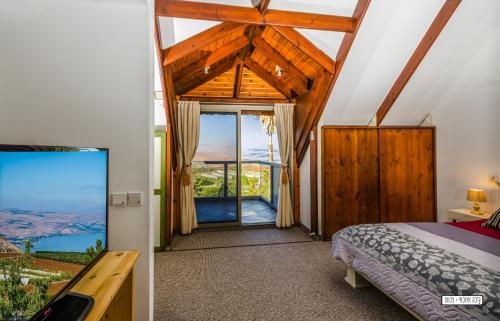 a bedroom with a bed and a large window at Beautiful Lake View Wooden House in Tiberias