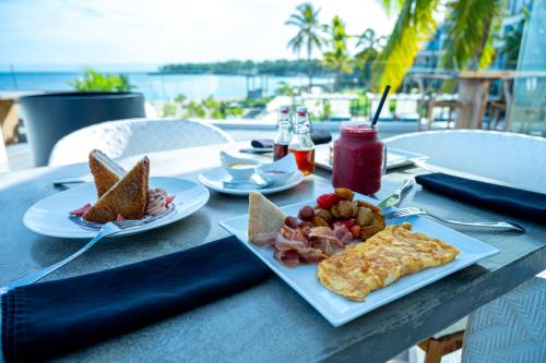 a table with a plate of breakfast food on it at The Ocean Club, a Luxury Collection Resort, Costa Norte in Sosúa