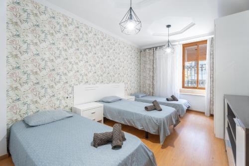 a room with three beds and a tv at Oasis de Valencia in Valencia
