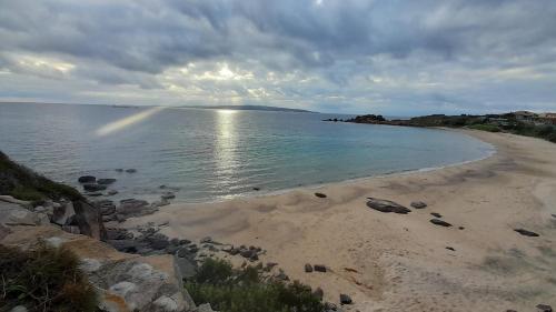 a beach with the sun shining on the water at B&B Nuovo Capo Altano in Portoscuso
