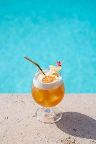 a drink sitting on the sand next to a pool at Borgo San Luigi in Monteriggioni