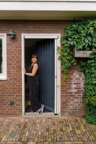 a woman standing in the doorway of a door at De Juffer van Batinghe in Dwingeloo