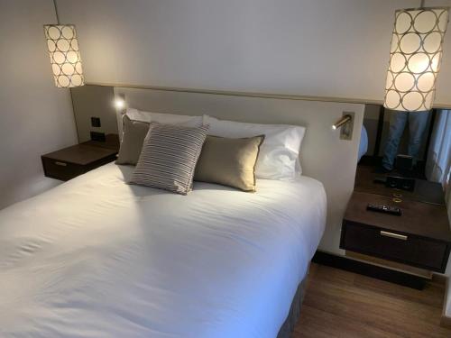 a large white bed with two pillows on it at Quatrecantons Camprodon in Camprodon