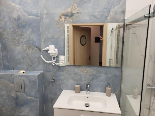 ein Badezimmer mit Waschbecken und Spiegel in der Unterkunft Plażowa Park 13 Międzywodzie in Międzywodzie